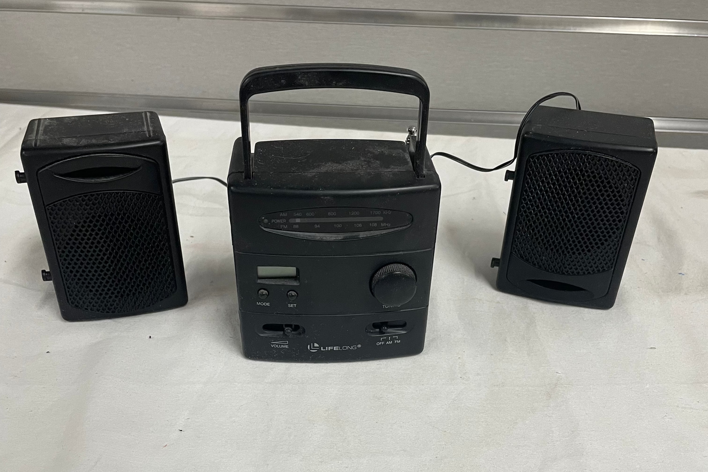 Lifelong Am/Fm Radio LCD Clock. Comes with two speakers attached. Item #8157.