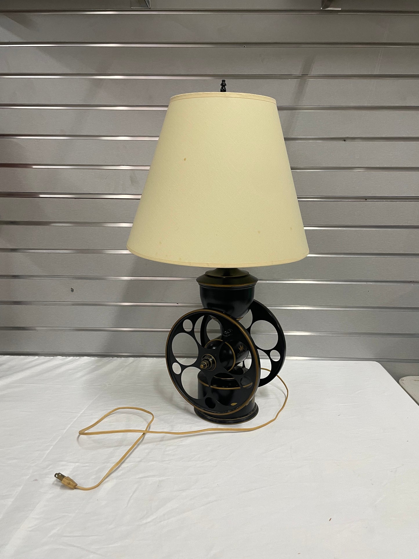 Black and Gold Wheel Lamp with Beige Lamp Shade. Lamp is 27” tall and shade is 14” wide.