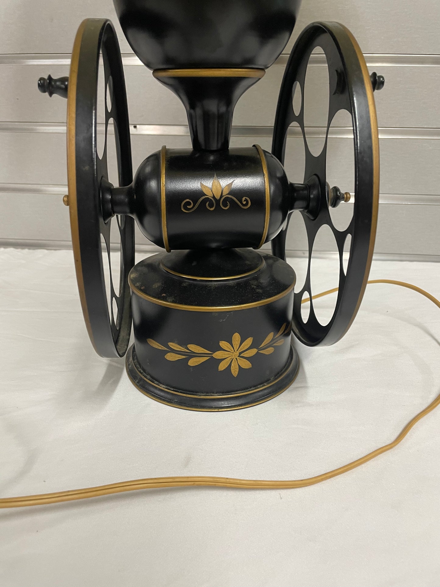 Black and Gold Wheel Lamp with Beige Lamp Shade. Lamp is 27” tall and shade is 14” wide.