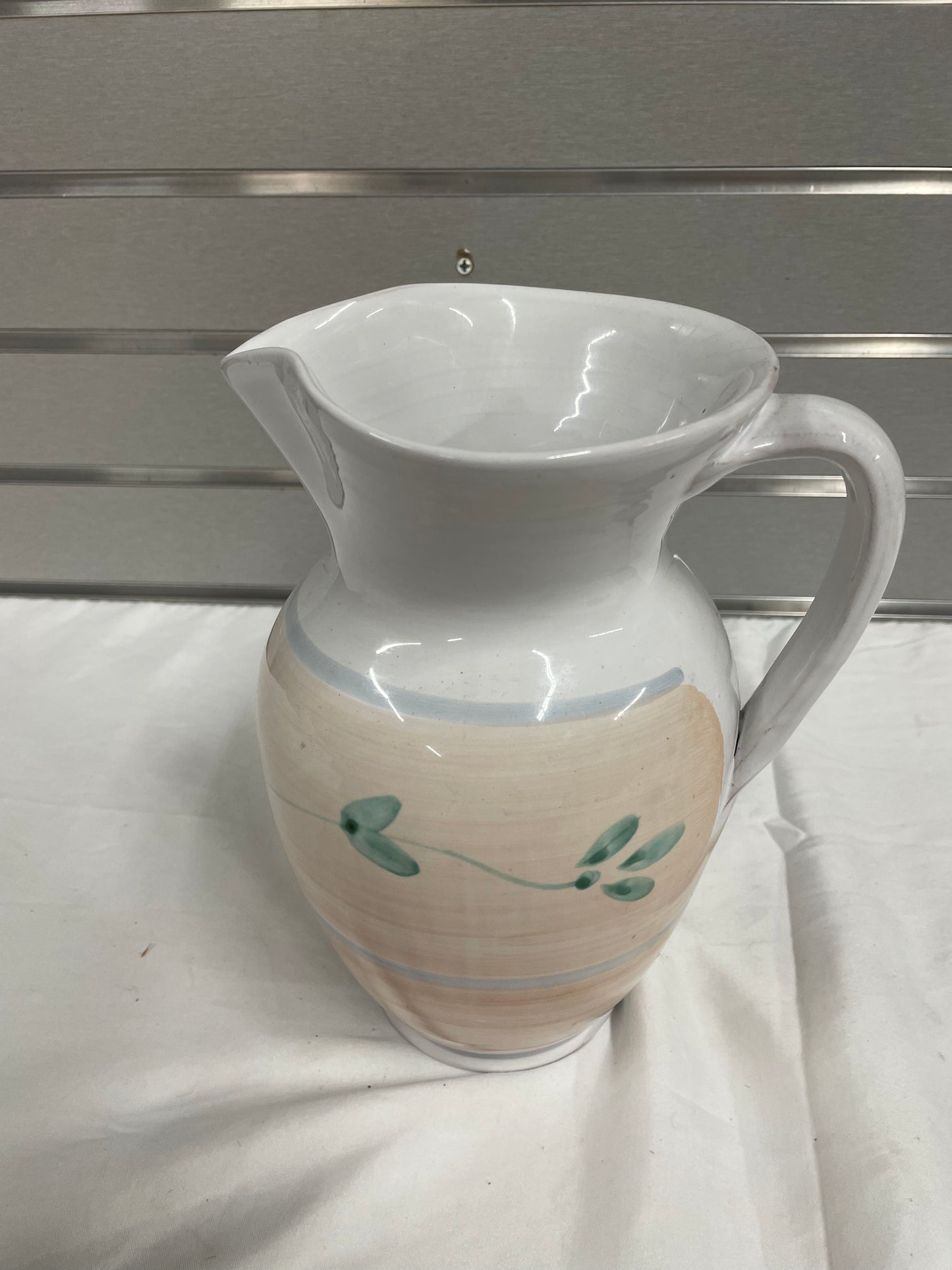 Old White Ceramic Pitcher. Pitcher is hand painted with flowers on sides